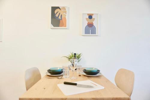 a dining room table with a wooden table and chairs at NEU modernes Apartment in Top Lage, free Parking max 1,65m Höhe und 1,8m Breite in Karlsruhe