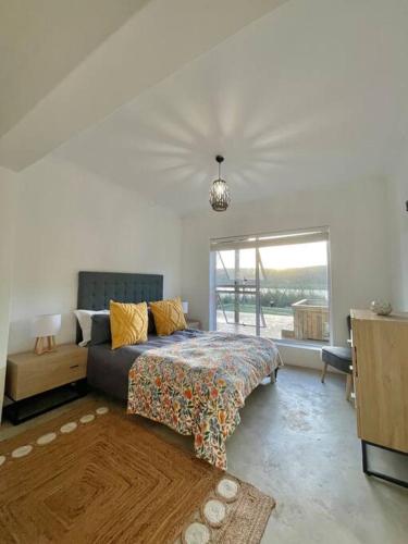 a living room with a bed and a window at Living The Breede-Lorigan House in Malgas