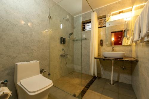 a bathroom with a toilet and a sink and a shower at Nihita I Yoga, Spa, retreat in Dod Ballāpur