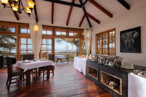 a dining room with a table and a fireplace at Lions Paw Ngorongoro in Ngorongoro