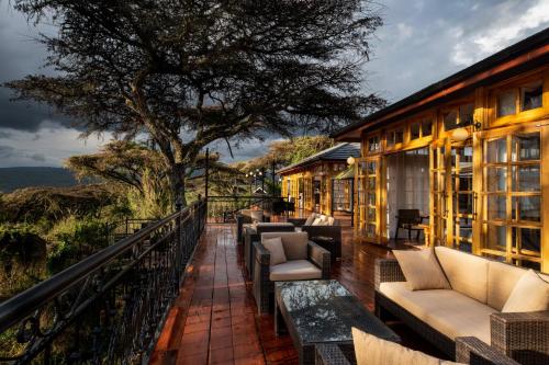 a balcony of a building with couches and chairs at Lions Paw Ngorongoro in Ngorongoro
