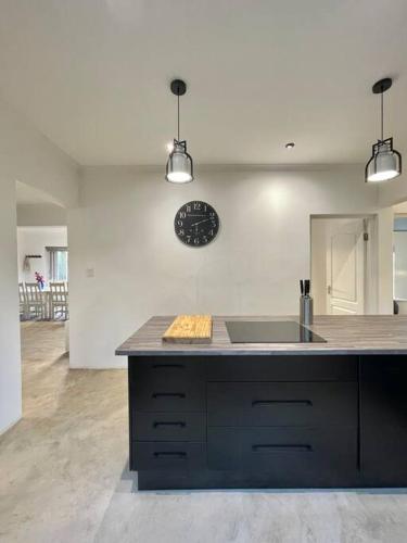 a kitchen with a sink and a clock on the wall at Living The Breede-Lorigan House in Malgas