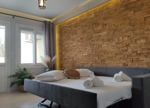 納克索喬拉的住宿－Iliopetra Apartment，一间卧室设有一张床和砖墙
