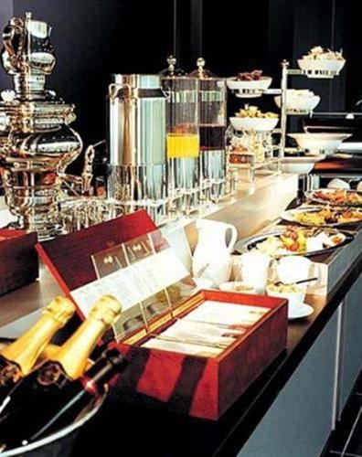 a buffet with a bottle of wine and a table with food at Kult Hotel in Ingolstadt