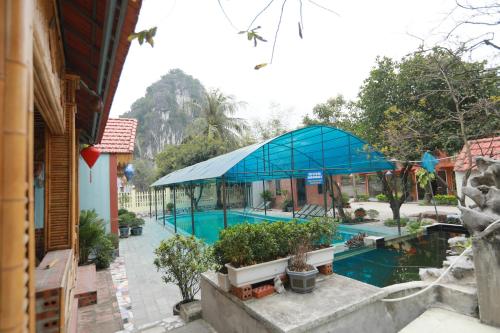 an overhead view of a swimming pool with a blue building at Trang An Elegant Homestay in Ninh Binh