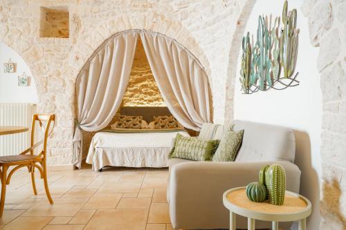 ein Wohnzimmer mit einem Sofa und einem Bett in der Unterkunft Trulli di Zia Vittoria in Alberobello