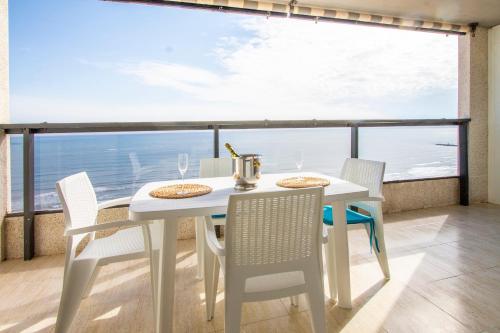 庫列拉的住宿－ESPACIO 18 - Primera Línea de Playa，白色的桌椅,享有海景