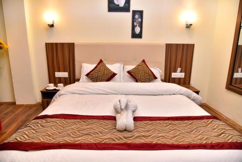 a hotel room with a bed with a pair of legs on it at Rufina Palm Bliss in Pelling