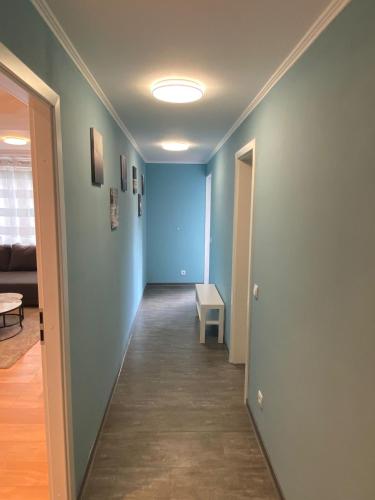 a hallway with blue walls and a table in a room at Eliz Appartements in Ringsheim