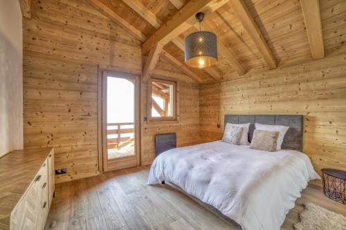 ein Schlafzimmer in einem Blockhaus mit einem Bett in der Unterkunft Chalet face au Mont-blanc in Sallanches