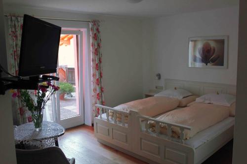 a bedroom with a bed with a television and a window at Haus Senoner in Kitzbühel
