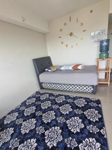 ein Schlafzimmer mit 2 Betten und einer Uhr an der Wand in der Unterkunft Apartemen in Pondoklang