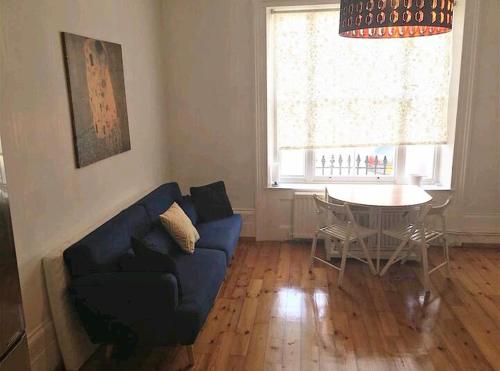a living room with a blue couch and a table at One bedroom with garden in London