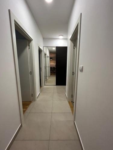 a hallway with white walls and a tile floor at Kej Garden - Two bedroom apartment. in Novi Sad