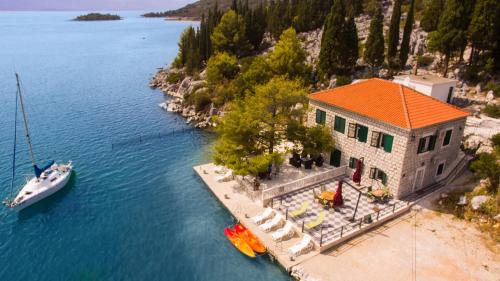 uma vista aérea de uma casa sobre a água com um barco em Adriatic Sunrise - Beach House em Blace