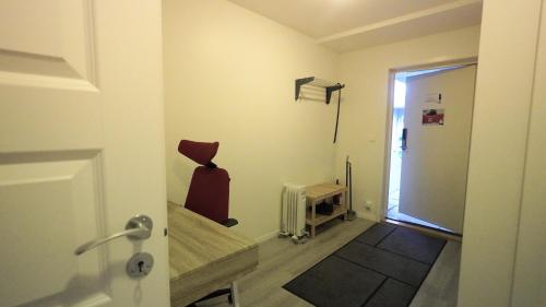 um quarto com uma cadeira vermelha sentado num quarto em Apartment with two bedrooms and parking em Stavanger