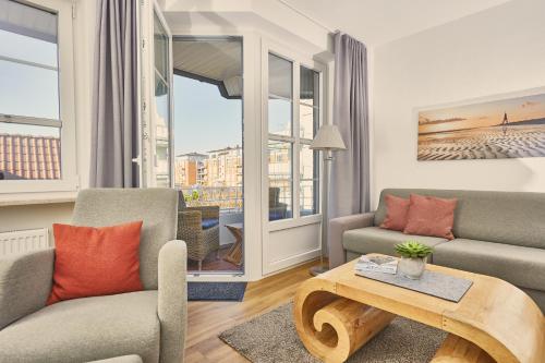 a living room with two couches and a table at Haus Wattenblick in Cuxhaven