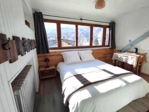 a bedroom with a white bed and a window at Chez Pierrot Chambres d'hôtes B&B in Vallouise