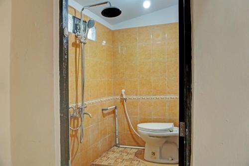 y baño con aseo y cabina de ducha. en Capital O 92316 Wisma Widya Loka Pratama, 