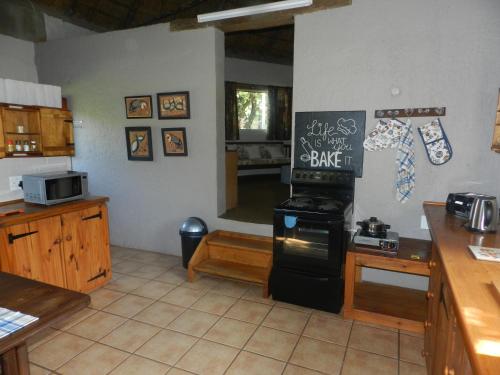 a kitchen with a stove top oven in a room at Cozy cottage in the Cradle of Humankind in Muldersdrift
