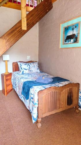 a bedroom with a bed with a wooden frame at Cozy cottage in the Cradle of Humankind in Muldersdrift