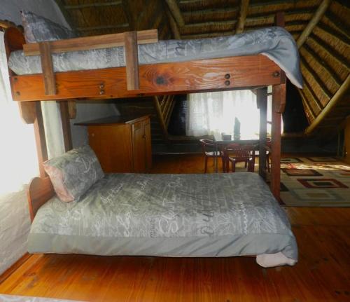 a bedroom with a bunk bed and a table at Cozy cottage in the Cradle of Humankind in Muldersdrift