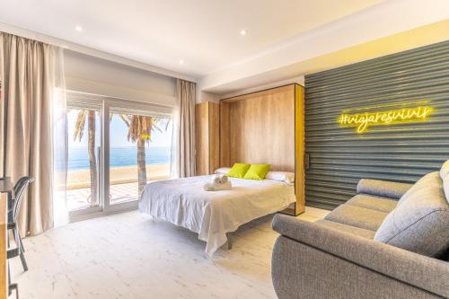 ein Schlafzimmer mit einem Bett, einem Sofa und einem Fenster in der Unterkunft Expoholidays- Apartaments Paseo Marítimo in Almería