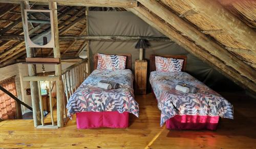a bedroom with two beds in a attic at Cozy cottage in the Cradle of Humankind in Muldersdrift