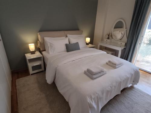 um quarto com uma grande cama branca com toalhas em Central & Comfortable, 70m² Apt in Neos Kosmos em Atenas