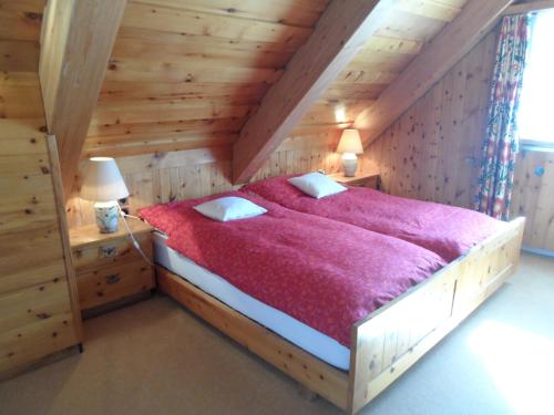 a bedroom with a large bed with a red blanket at Chalet Atelier in Davos