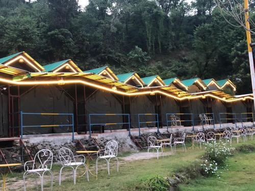 a row of tables and chairs in front of a tent at CAMPSITE in Shivpuri