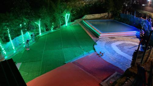 a swimming pool with lights on it at night at CAMPSITE in Shivpuri