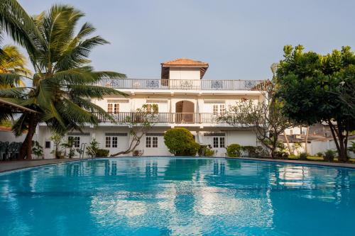 a large swimming pool in front of a building at Navro Beach Resort in Panadura