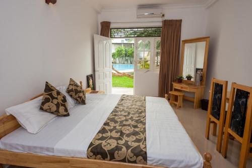 a bedroom with a large bed and a mirror at Navro Beach Resort in Panadura