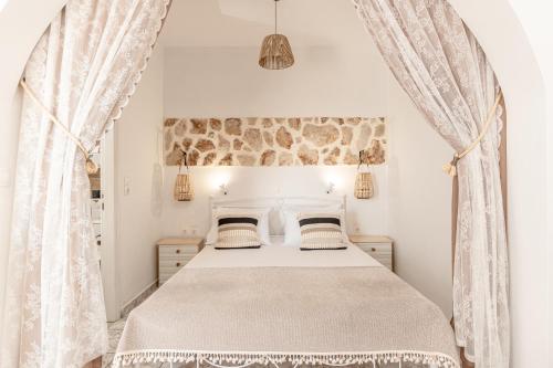 1 dormitorio con 1 cama grande y cortinas blancas en Studios Tasia en Agios Prokopios