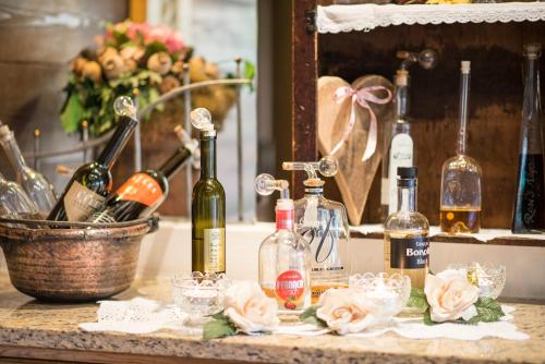 a bunch of bottles of wine on a counter with flowers at Familien- & Vitalhotel Auenhof in Fulpmes