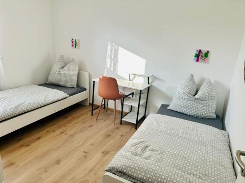 a small room with two beds and a desk at Die Ibbenbürener Ferienstube in Ibbenbüren