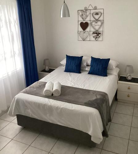 a bedroom with a large white bed with blue pillows at Nomads Nook 15 in Ramsgate