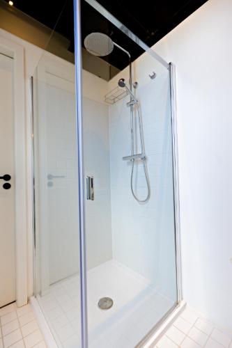 a shower with a glass door in a bathroom at Luxury Suites Princess by Rikas Hotels in Antwerp