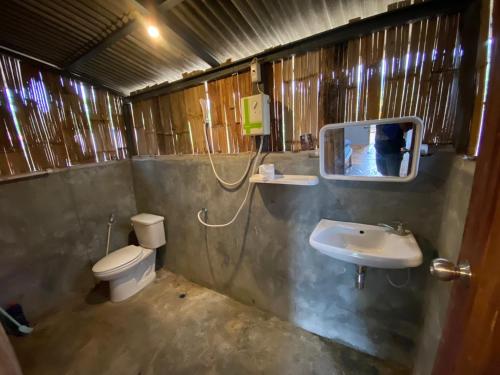 a bathroom with a toilet and a sink and a mirror at Red orchid pai Thailand in Pai