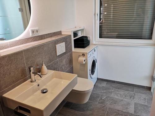 a bathroom with a sink and a washing machine at Good times @ Salzburg in Habach