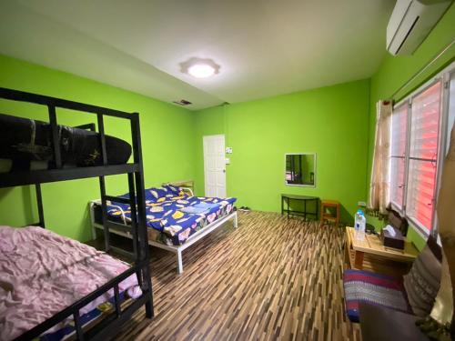 1 dormitorio con 2 literas y paredes verdes en Red orchid pai Thailand, en Pai