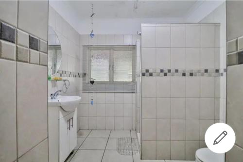 een badkamer met douche, wastafel en toilet bij St Lucia Safari Logde Holiday Home in St Lucia