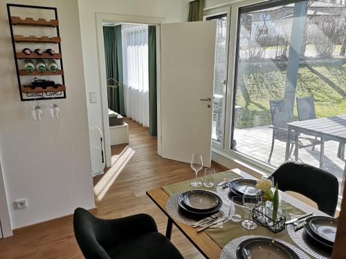 a dining room with a table and chairs and a room with a window at Good times @ Salzburg in Habach