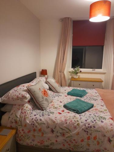 1 dormitorio con 1 cama con manta de flores en The old post office Callander holiday let en Callander