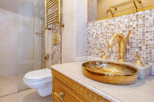 y baño con lavabo de cobre y aseo. en Exquisite Studio in Historic Mansion in Beylerbeyi, en Estambul
