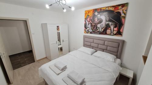 sypialnia z łóżkiem i obrazem na ścianie w obiekcie PABLO PICASSO Premium Apartman w Niszu