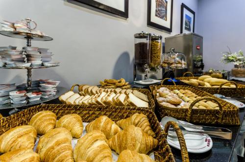 a buffet filled with lots of bread and baskets of pastries at Virgen de los Reyes in Seville