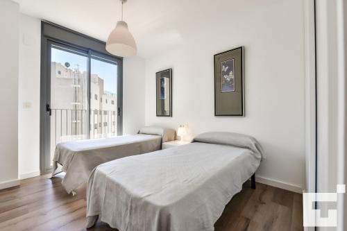 Duas camas num quarto com uma janela grande em Apartamento Isea 153 - Grupo Turis em Calpe