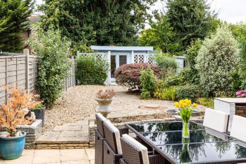 a garden with a table and a pond at Lovely House in Welwyn with Garden and Off road parking in Welwyn Garden City